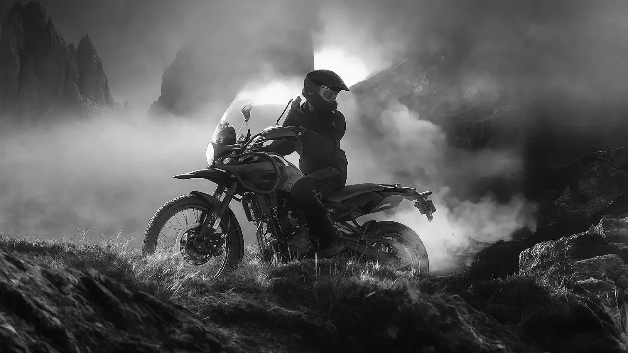 Himalayan Mana Black Edition adventure bike in stealth black riding through rocky mountain terrain